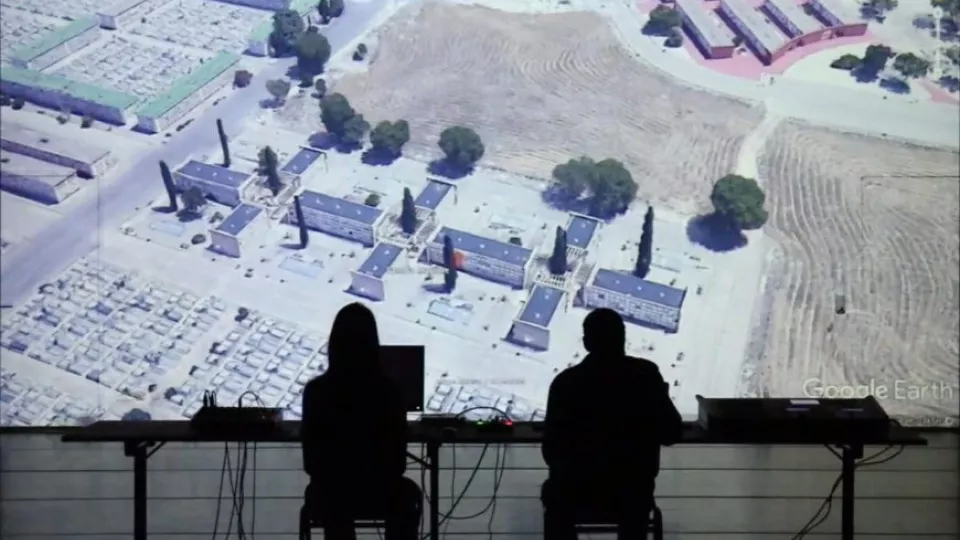 två personer framför en stor skärm med en karta