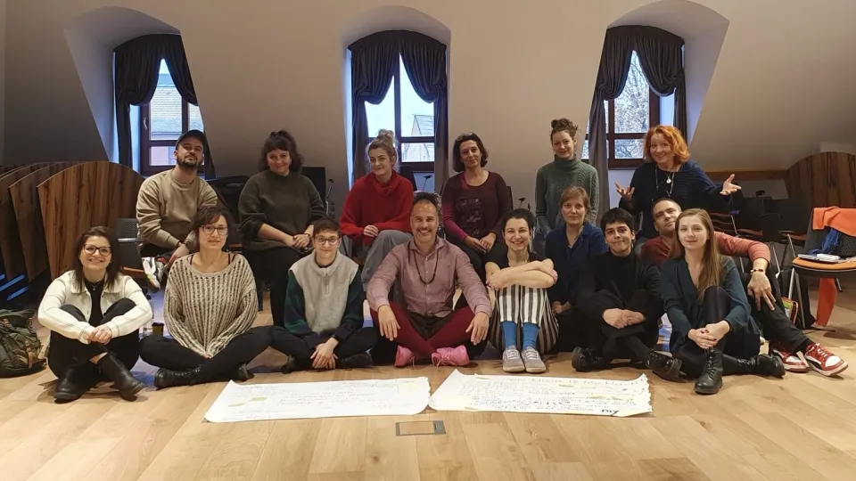 Personer sitter i grupp på golvet. Foto. 