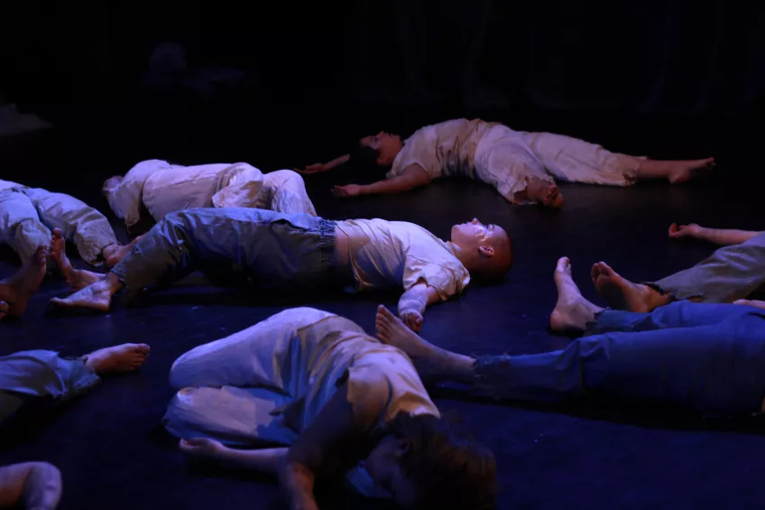 En bild med personer som ligger på golvet under en föreställning. 